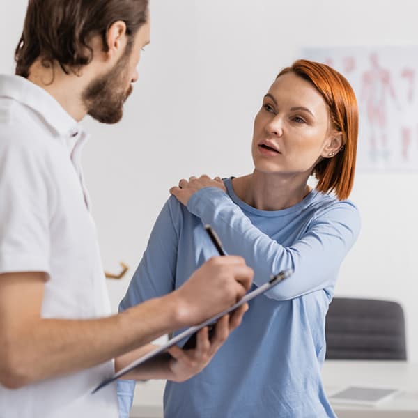 woman talking to her physical therapist following up on care